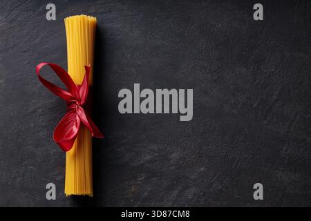 Raw Dry Spaghetti Tied in Bundle on Dark Surface Italian Cuisine Stock Photo