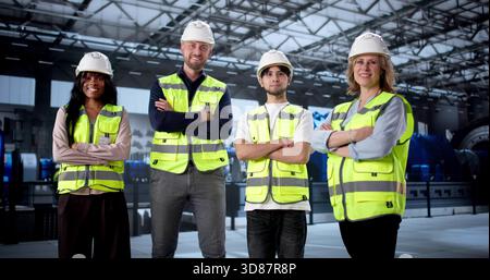 Engineer Supervising Diverse Workers At Gas Power Plant Turbines. Stock Photo