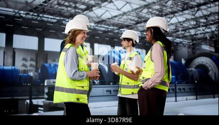 Diverse Team Of Workers Enjoying Coffee Break At Power Plant. Stock Photo