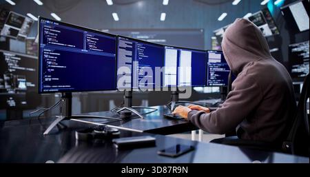 Mid-aged Caucasian Man In Hoodie Stealing Data Online Using Computers. Stock Photo