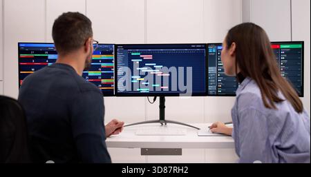 Female Analyst And Male Manager Collaborating On Office Project Schedule. Stock Photo