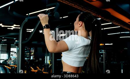 Woman is doing bicep curls with dumbbells Stock Photo