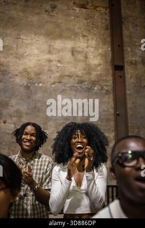 Excited curly haired woman cheering while watching play in stage theater Stock Photo