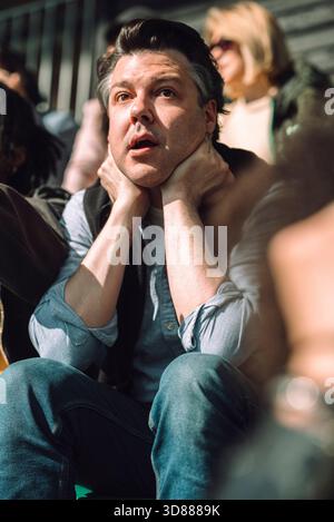 Shocked mature man leaning on elbows while sitting and watching game in stadium stand Stock Photo
