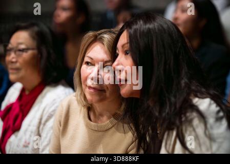 Focused female friends watching play at theater Stock Photo