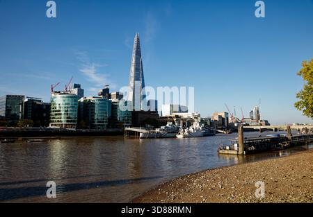 The World War 2 battleship, HMS Belfast; moored on the Thames beneath the soaring heights of The Shard, Southwark, London, England. Stock Photo