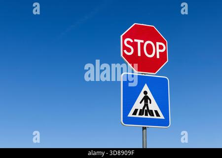 A red octagonal stop sign is positioned below a blue circular sign ...