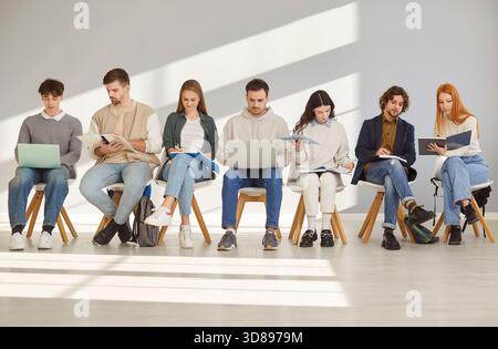 Young business people sitting in a row with preparing for meeting or conference Stock Photo