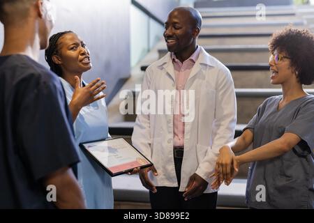 In hospital, medical professionals holding certificate, discussing achievements, smiling together. Healthcare, teamwork, recognition, award, collaboration, success || Model released Stock Photo
