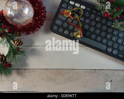 Festive Workspace with Keyboard - Christmas-themed workspace flat lay featuring a modern black keyboard, sparkling ornaments, and natural evergreen el Stock Photo
