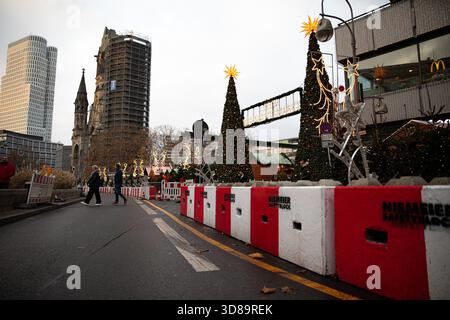 Berlin, Berlin, Germany. 29th Nov, 2025. Visitors walked past security barriers at the Christmas market on Breitscheidplatz in Berlin on Saturday, November 29, 2025, as crowds moved through the stalls surrounding the Kaiser Wilhelm Memorial Church. The reinforced blocks and fenced entry points remain a standard feature at the site, introduced after past security concerns and now part of the market's annual layout. Despite the visible precautions, the market drew steady foot traffic from locals and tourists enjoying food stands, holiday lights, and the start of Berlin's winter festivities. ( Stock Photo