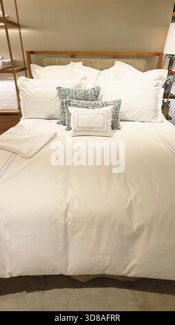 Berlin, Germany - September 19, 2025: Luxurious white bedding set features decorative pillows on a stylish bed with soft textures. Stock Photo