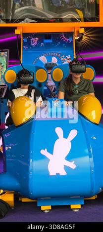 Berlin, Germany - September 22, 2025: Two kids are experiencing a virtual reality ride in a vibrant gaming arcade. Stock Photo
