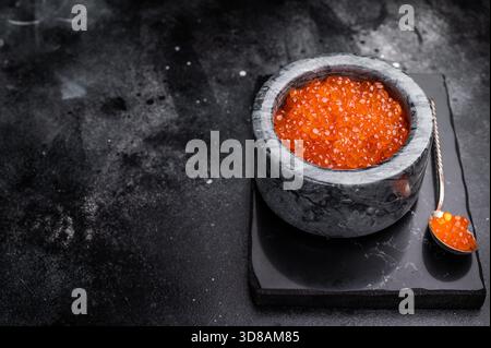 Exquisite salmon roe, vibrant and rich, ideal for adding a touch of elegance to your culinary creations. black background. top view. Stock Photo