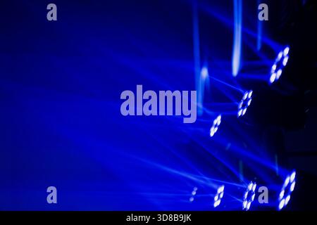 Moving head LED fixtures generating layered blue light textures and sweeping beams, forming an abstract visual pattern within a professional event pro Stock Photo