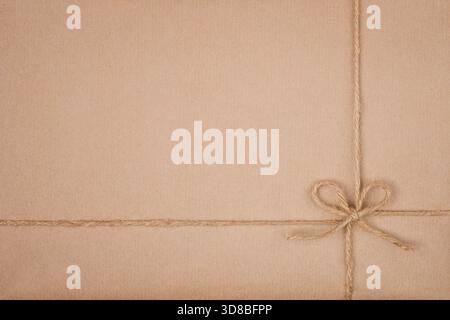Twine String Tied in Bow on Kraft Eco Friendly Paper Texture Stock Photo