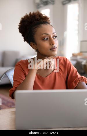Serious dreamy African American woman working on freelance project Stock Photo