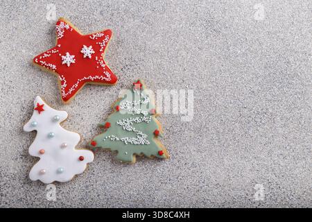 Gingerbread cookies decorated with icing sugar on grey stone background, winter holidays baking Stock Photo