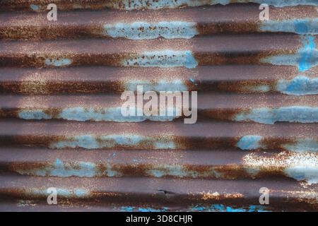 Add an authentic, weathered touch with this distressed corrugated metal texture featuring rust and blue, perfect for backgrounds and industrial design Stock Photo