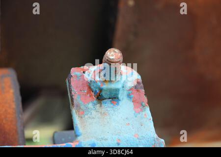 Unique textures and weathered charm of a rusty bolt with peeling paint. Perfect for adding an industrial, grunge, or vintage feel to your creative pro Stock Photo