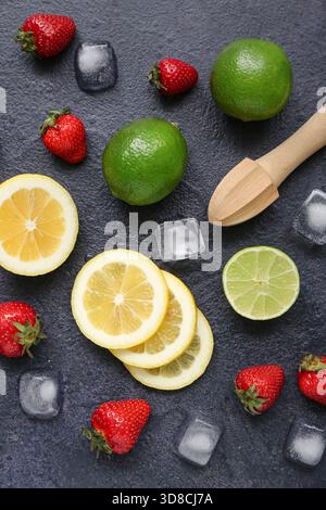 Juicer and ingredients for preparing strawberry lemonade on black background Stock Photo