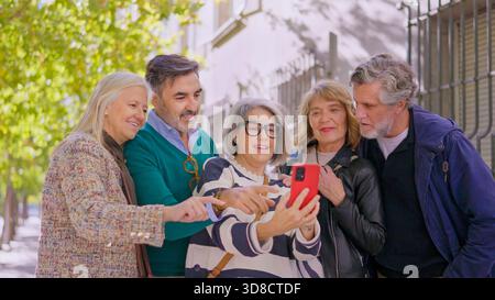 Happy senior friends taking a selfie together outdoors Stock Photo