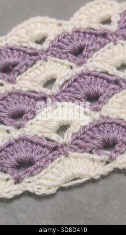 Knitting patterns for sweaters, hats, and other items using light-colored yarn on a light background. Copy space. Stock Photo