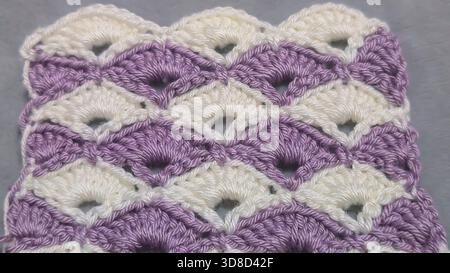 Knitting patterns for sweaters, hats, and other items using light-colored yarn on a light background. Copy space. Stock Photo