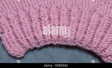 Knitting patterns for sweaters, hats, and other items using light-colored yarn on a light background. Copy space. Stock Photo
