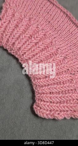 Knitting patterns for sweaters, hats, and other items using light-colored yarn on a light background. Copy space. Stock Photo