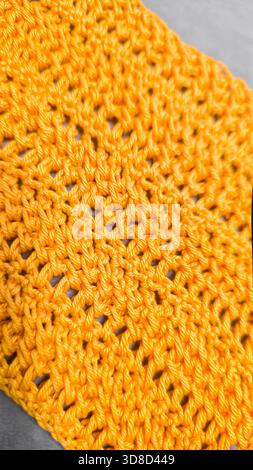 Knitting patterns for sweaters, hats, and other items using light-colored yarn on a light background. Copy space. Stock Photo