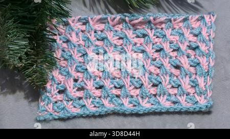 Knitting patterns for sweaters, hats, and other items using light-colored yarn on a light background. Copy space. Stock Photo
