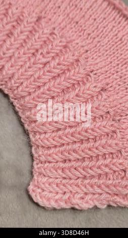 Knitting patterns for sweaters, hats, and other items using light-colored yarn on a light background. Copy space. Stock Photo