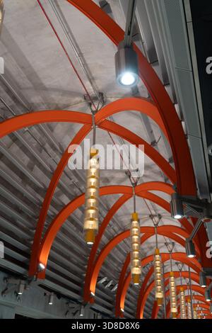 Melbourne, VIC, Australia. November 30, 2025. - The dynamic ceiling architecture of Town Hall Station features repeating bright orange arches and cont Stock Photo