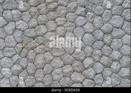 Textured gray stone wall with interlocking hexagonal pattern Stock Photo