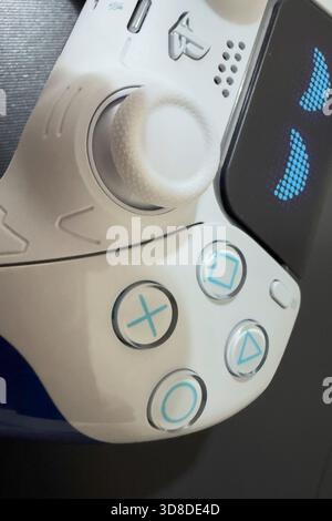 Doha, Qatar - November 28, 2025: A gamer is playing Play Station 5 at home, his hand holding Dual sense joystick which is the new wireless controller. Stock Photo
