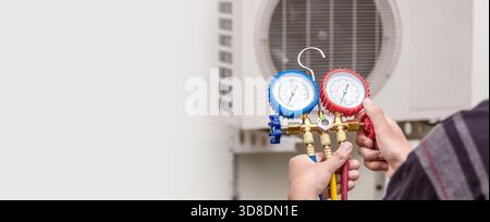 Technician checking the operation of the air conditioner Stock Photo