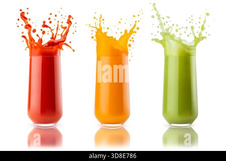 Fresh green vegetable juices of different colors with flying drops, splashing in glasses isolated on white background. Collection of three glasses. Red, orange, green juices for healthy fitness menu. Stock Photo