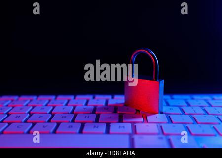 A metal padlock sits on a computer keyboard, symbolizing the importance of cyber security and protecting sensitive data in the digital world. The sett Stock Photo