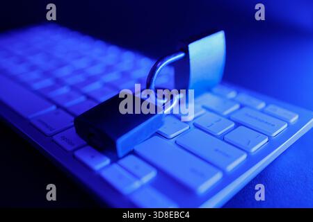 A padlock rests on a computer keyboard, symbolizing the critical need for cyber security in today's digital landscape. This scene emphasizes the ongoi Stock Photo
