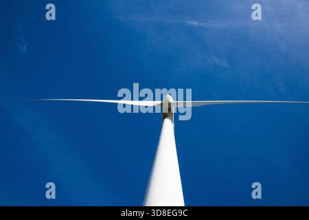 Ground-level close-up photo looking up at a wind turbine in the UK, highlighting clean energy, modern engineering and renewable power. Stock Photo