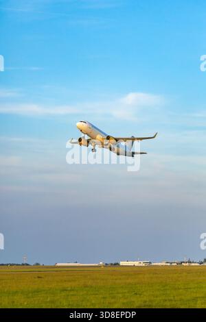 Commercial airplane departing for travel, flying into a clear sky over Hostivice, Czechia Stock Photo