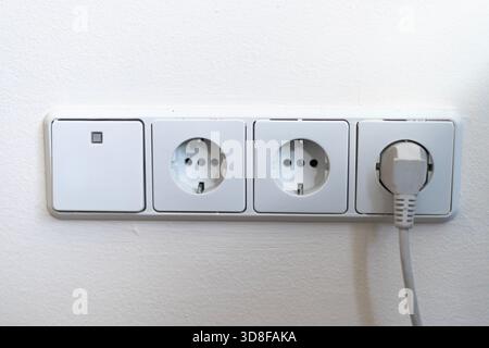 Electrical outlets and light switch on the wall Stock Photo