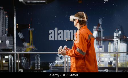 Male engineer using virtual reality equipment to inspect offshore drilling rig, applying advanced visualization for oil platform operations, maintenance and manufacturing systems. Stock Photo