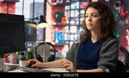 IT expert writing code and debugging on artificial intelligence neural networks computerized brain model. Woman tech support doing checkup on AI systems, cloud computing. Camera B. Stock Photo