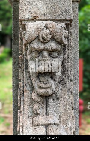 Italy - Caprarola - Palazzo Farnese - Close up of a grotesque stone mask carved on a herm in the gardens Stock Photo