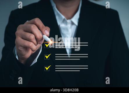 Businesswoman using digital pen to mark checklist items on virtual interface, representing verification, task management, auditing, project review, an Stock Photo
