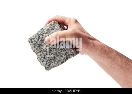 Human hand holding a pave granite stone cube down Stock Photo