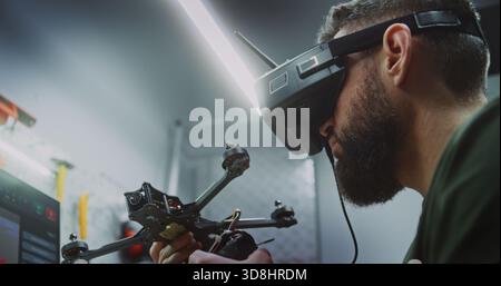 Close Up of Technician Calibrating FPV Drones. Man Checking Speed Controllers and Calibrating Components on Quadcopter Frames. Concept of Intensive Assembly and Calibration Process Drone Production. Stock Photo