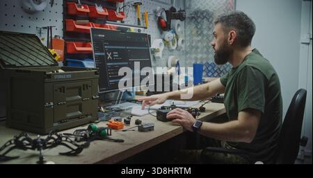 Engineer Combining Software Design With Physical Drone Assembly. Man Works Meticulously Organized Bench, Combining Software Design on Monitor With Physical Assembly Complex Drone. Technical Precision. Stock Photo